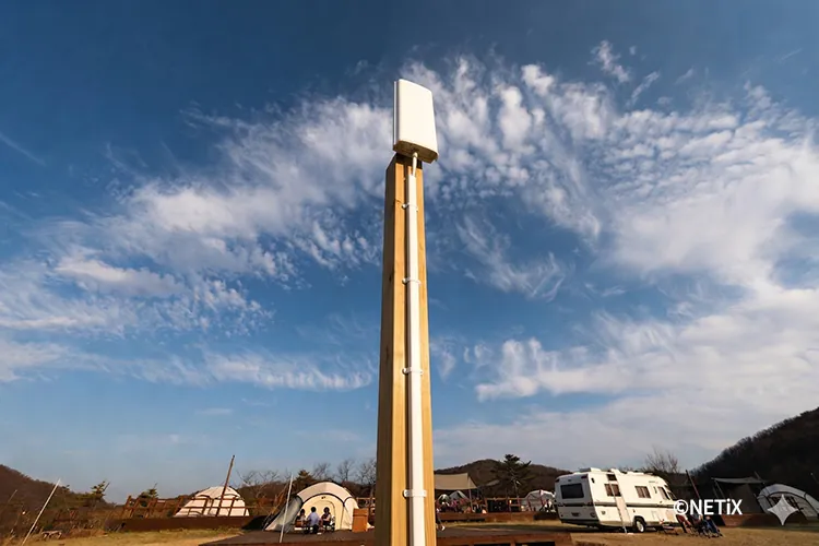 넓은 자갈밭 부지의 캠핑장에 음영 지역 없이 설치된 네틱스 무선 네트워크 시설 전경